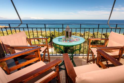 a balcony with chairs and a table with a view of the ocean at Eros Pittoresque Retreats - Perfect location, Panoramic Seaview in Koroni