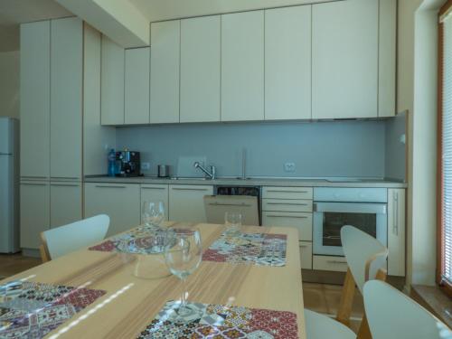 una cocina con una mesa de madera con copas de vino. en Private Apartment in Cypress Complex 15, en Varna