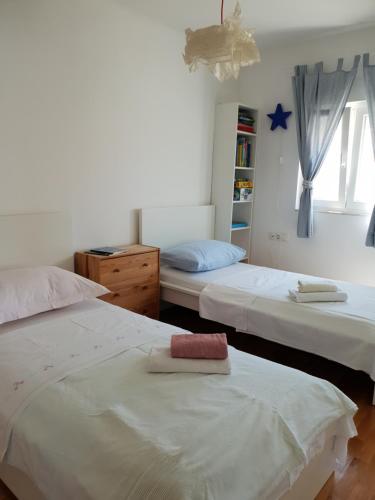 a bedroom with two beds and a book shelf at Cozy apartments with seafront terraces in Omiš
