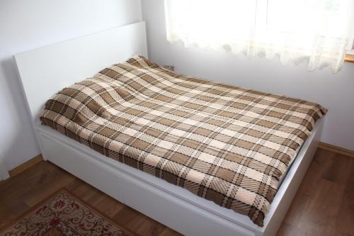 a bed in a room with a blanket on it at Domek w NABO in Załuski