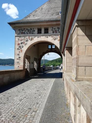 a bridge over a river with a person walking under it at Haus Blick am Edersee in Waldeck