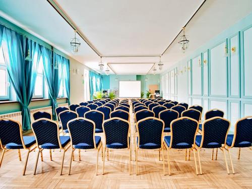 a room with a row of chairs and a screen at Miodosytnia Aparthotel in Kraków