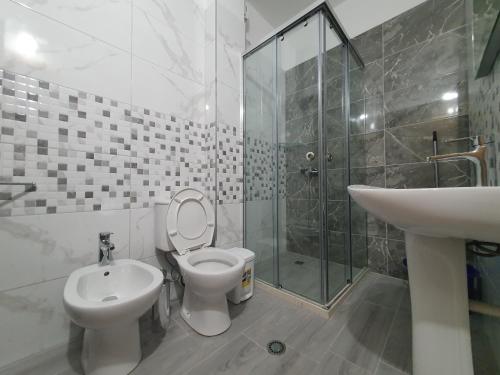 a bathroom with a toilet and a sink and a shower at Seaview Apartments in Vlorë