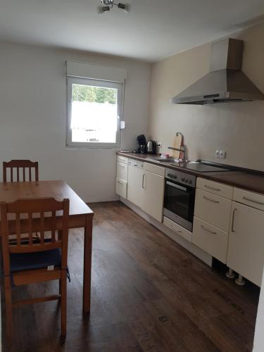 a kitchen with a table and a stove top oven at Westerwald Apartments in Straßenhaus