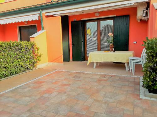 a table and chairs on the patio of a house at RESORT VILLAGE AQUA MARINA FAMILY - Daily Rooms Tidying - CocktailsBar- Pet Friendly - with Hypermarket - Delivery Restaurant-Pizzeria - Room Breakfast with supplement - Ultra Fast Wi-Fi - Play Area for children - Olympic Swimming Pool - Parking in Caorle