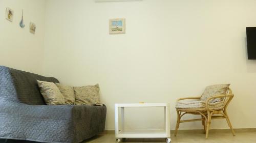 a living room with a couch and a chair at Eco Apartments Kate in Suđurađ