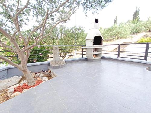 a patio with a pizza oven on a fence at Apartment Prancic in Nečujam
