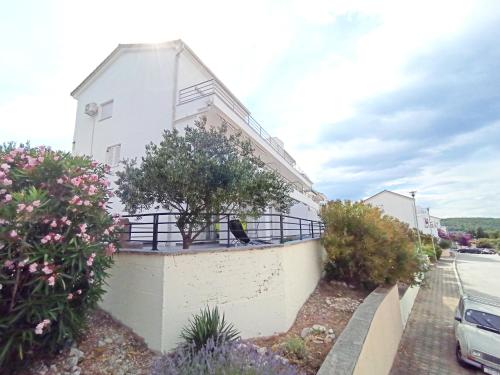 a white house with a bird sitting on a wall at Apartment Prancic in Nečujam