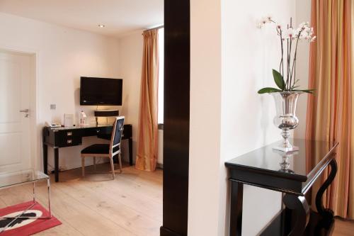 a room with a desk and a vase with flowers on a table at Altes Zollhaus in Rinteln
