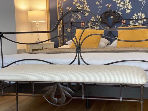 two beds with yellow pillows and a bench in a bedroom at Bel Appartement - Brive Centre - Quartier Musée in Brive-la-Gaillarde