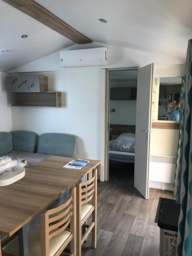 un salon avec une table et une chambre avec un lit dans l'établissement Mobile Home 701, aux Mathes