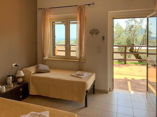 a bedroom with two beds and a large window at Agriturismo Podere Pansera in Petrizzi