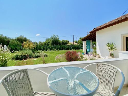 a glass table and chairs on a balcony at Villa Doma with private pool for up to 29 guests by DadoVillas in Roda