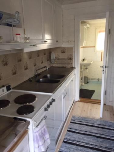 uma cozinha com um lavatório e uma bancada em Stuga med havsutsikt i Sankt Anna em Sankt Anna