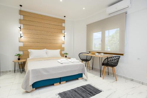 ein Schlafzimmer mit einem Bett, einem Tisch und Stühlen in der Unterkunft Studios Passa in Limenaria