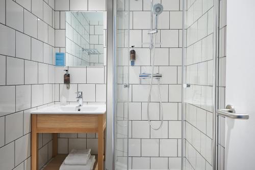 a bathroom with a sink and a shower at Hôtel Stanley by HappyCulture in Nancy