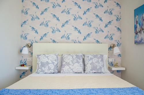 una camera da letto con un letto con carta da parati blu e bianca di La casa di paola a SantʼAntonio Abate