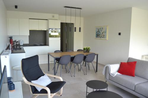 uma cozinha e sala de estar com mesa e cadeiras em Karthuizer Duinpoort em Nieuwpoort