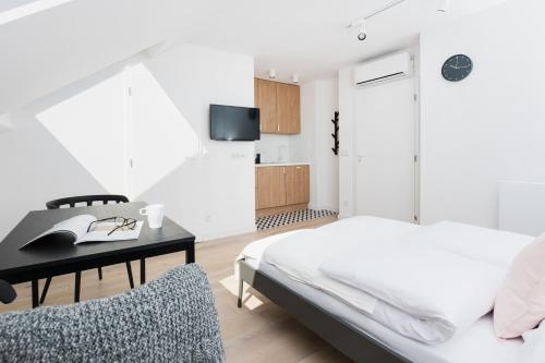 um quarto com uma cama, uma secretária e uma televisão em Chillax Apartments em Zator