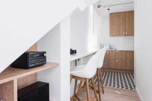 a kitchen with a white counter and a white chair at Chillax Apartments in Zator
