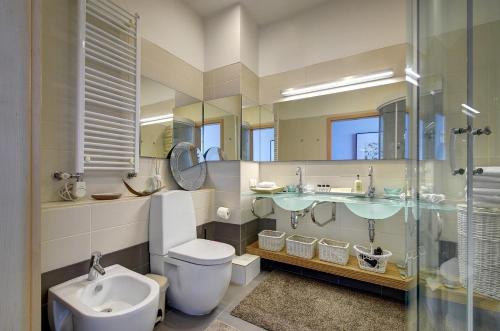 a bathroom with a toilet and a sink and a mirror at Helios apartment in Vilnius skyscraper in Vilnius