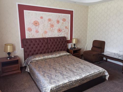 マハチカラにあるHotel Centralのベッドと椅子付きのホテルルーム