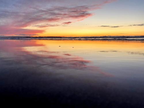 a sunset on the beach with the water at McMunns of Ballybunion in Ballybunion
