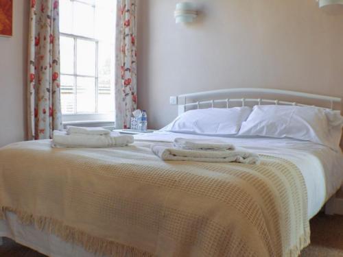 a bedroom with a bed with two towels on it at Chapter Two Bar in Malton