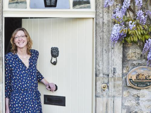a woman standing in the door of a building at Rook Lane House in Frome