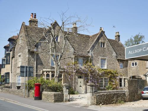 uma velha casa de pedra na esquina de uma rua em Rook Lane House em Frome