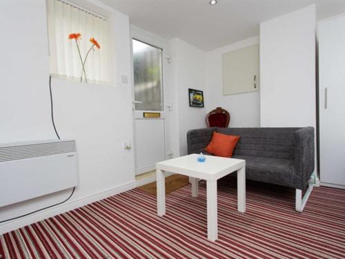 ein Wohnzimmer mit einem Sofa und einem Tisch in der Unterkunft Brownhill Studio in Leeds in Leeds