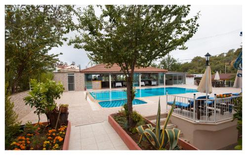 a swimming pool with a table and chairs next to a house at Mavi Yaprak Hotel in Oludeniz