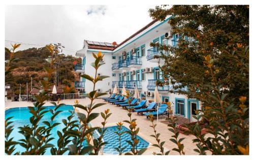 a hotel with blue chairs next to a swimming pool at Mavi Yaprak Hotel in Oludeniz