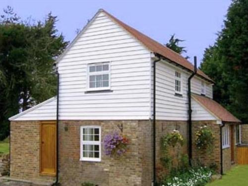 a brick and white house with at The Barn At Woodview in Hildenborough