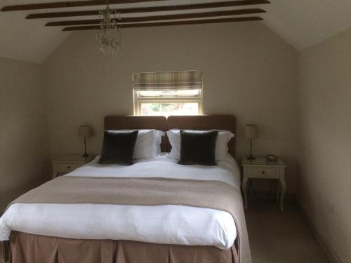 a bedroom with a large bed with pillows and a window at The Barn At Woodview in Hildenborough