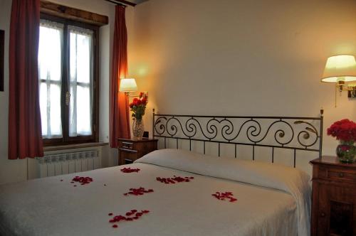 a bedroom with a bed with red flowers on it at I Casali Della Ghisleria in Ospedalicchio