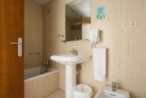 Hospedium Hotel Don Fidel في Cuarte de Huerva: حمام مع حوض وحوض استحمام