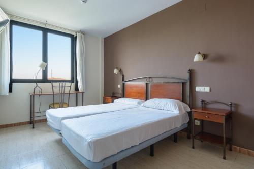 A bed or beds in a room at Hospedium Hotel Don Fidel