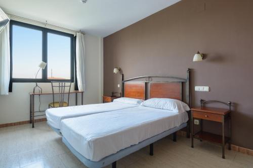 1 dormitorio con cama grande y ventana grande en Hospedium Hotel Don Fidel en Cuarte de Huerva