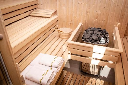 a sauna with a bench and a basket of rocks at Ułańska Zagroda in Człopa