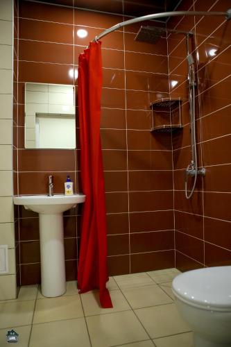 a bathroom with a red shower curtain and a sink at Guest House in Gyumri in Gyumri