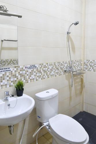 a bathroom with a toilet and a sink at Rich Guesthouse in Paalmerah