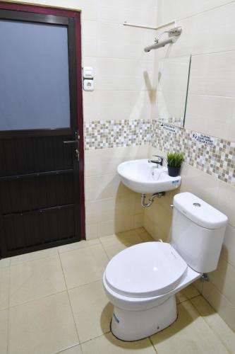 a bathroom with a toilet and a sink at Rich Guesthouse in Paalmerah