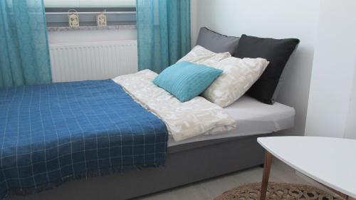 Schlafzimmer mit einem Bett mit blauen und weißen Kissen in der Unterkunft Apartament Pucka Przystań in Puck