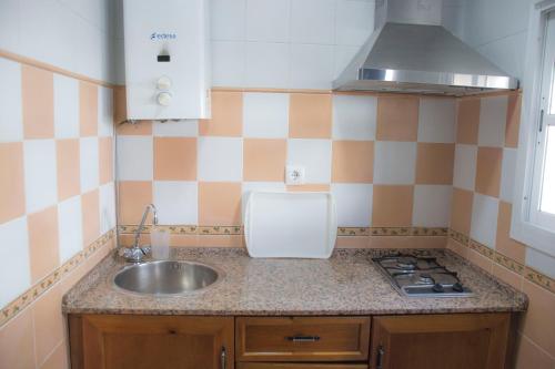 a small kitchen with a sink and a stove at Complejo Vacacional Los Cortijillos-Solo adultos in Conil de la Frontera