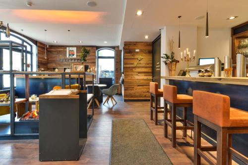 a restaurant with a bar and tables and chairs at Hotel Haunstetter Hof Augsburg in Augsburg