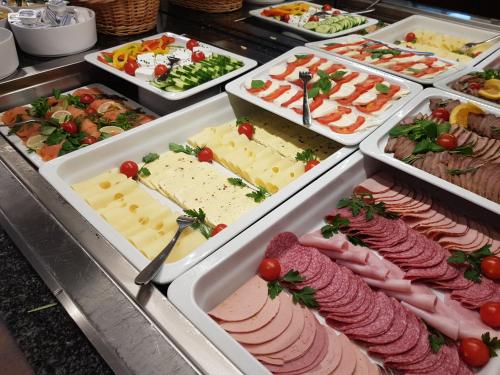 a buffet filled with different types of cheese and meats at Hotel Haunstetter Hof Augsburg in Augsburg