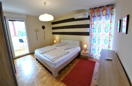 ein kleines Schlafzimmer mit einem Bett und einem Fenster in der Unterkunft Sunset Apartment in Pula