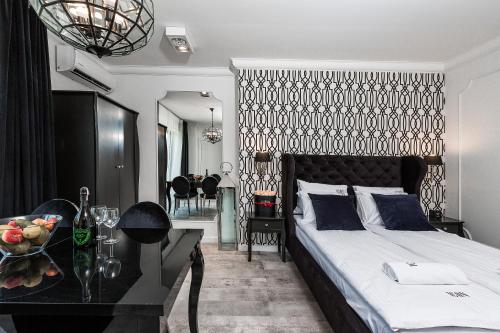 a bedroom with a bed and a table with a bowl of fruit at ICON APARTMENTS in Gdańsk