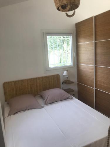 1 dormitorio con 1 cama blanca y ventana en LE NOMADE au Clos en Provence, en Flayosc